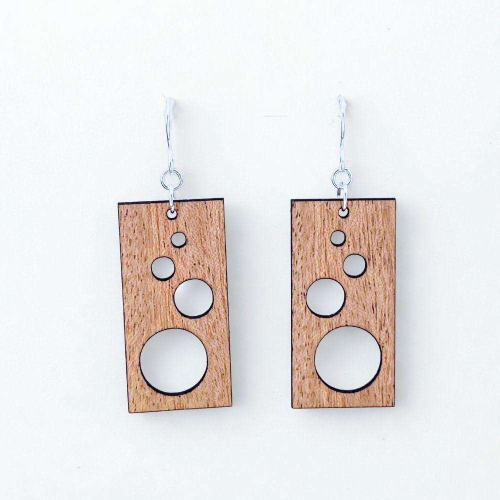 Handmade sustainable cherry wood and recycled sterling silver earrings against a white background.
