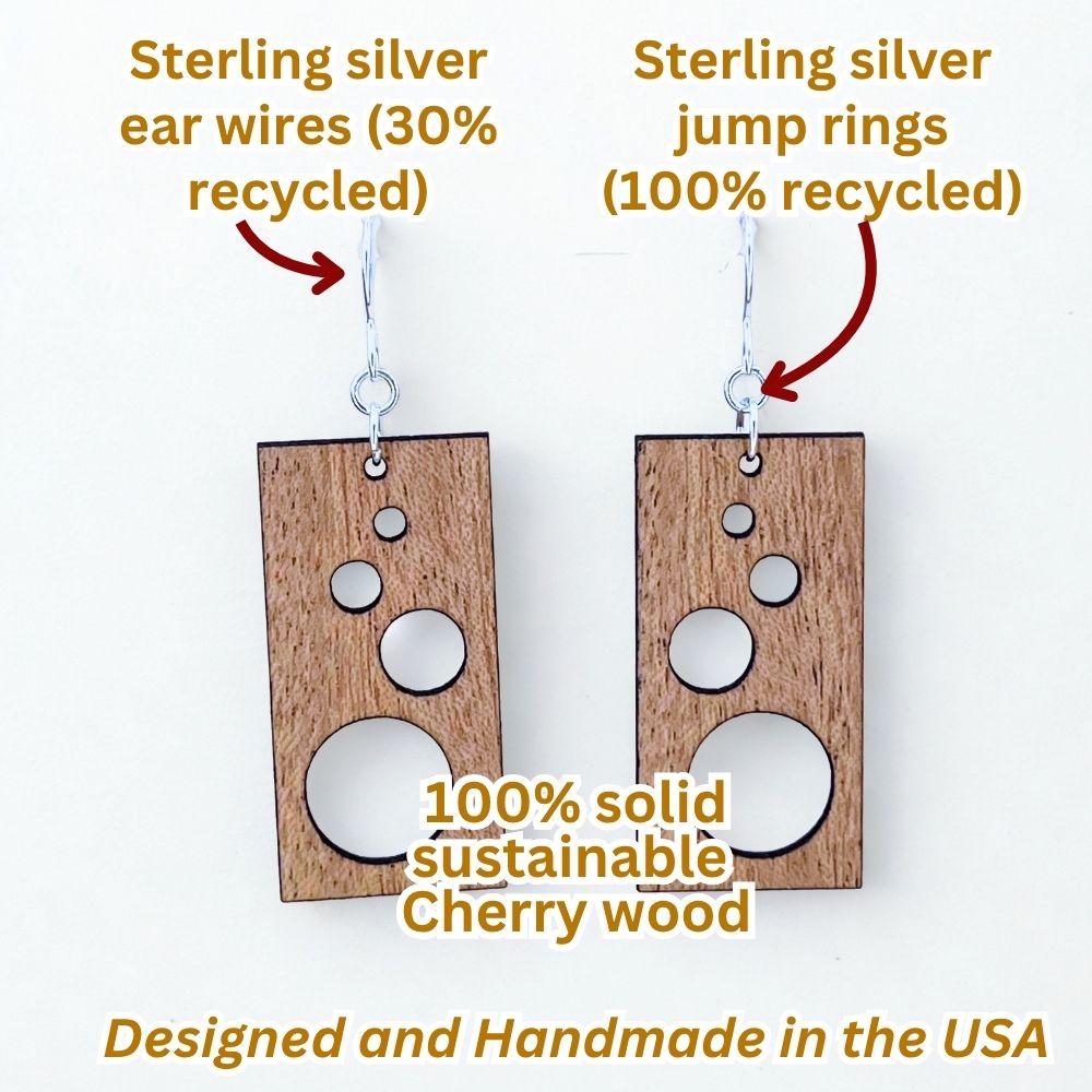 Rectangular solid cherry wood earrings with circle cutouts and recycled sterling silver on a white background to make an infographic, highlighting recycled materials and sustainability.