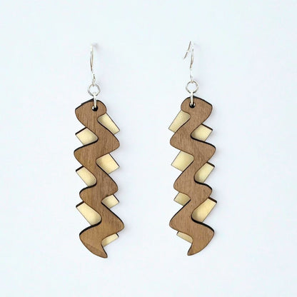 Wooden earrings with wavy design on a white background